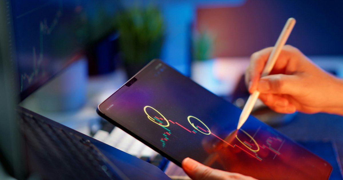 Someone is working on the tablet to analyze stock data.